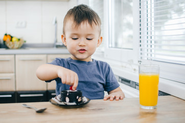 a young child tries a berry cupcake with curious and delicious