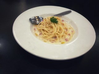Spaghetti carbonara with cream, mushroom and bacon. Delicious food in white dish.  