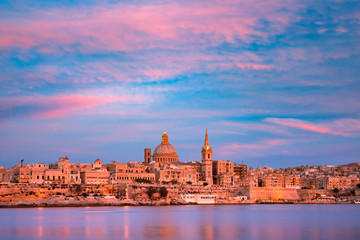 Valletta Skyline at beautiful sunset from Sliema with churches of Our Lady of Mount Carmel and St. Paul's Anglican Pro-Cathedral, Valletta, Capital city of Malta