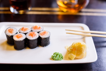 Fototapeta na wymiar Fresh sushi rolls served on plate in restaurant