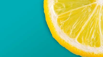 The half slice of the fresh lemon on cyan pastal color background
