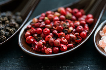 Close up pink peppercorn in spoon dark background