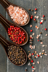 Close up pink himalayan salt and peppers in spoons