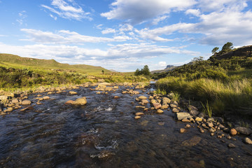 Stream flowing over rocks and clouds in the sky