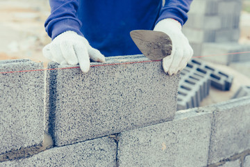 Bricklayer worker installing brick masonry.