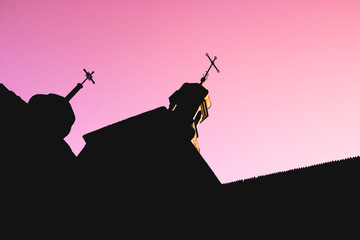 Black silhouette of wooden Church with domes and crosses on red and purple clear sky background,...