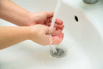 Fototapeta premium Woman washing hands with soap in sink
