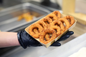 Chef or cook serving battered fried onion rings