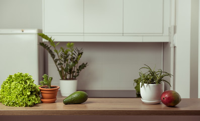 Avocado, mango and kiwi on the table in kitchen interior. Healthy vegetarian lifestyle concept. Copy space