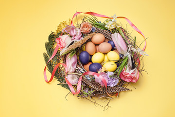 Easter card. Painted Easter eggs in nest on yellow background