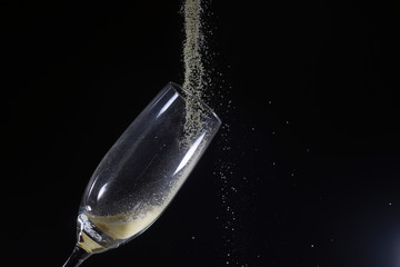 Desert liquor fine sand trickles into a champagne glass 
