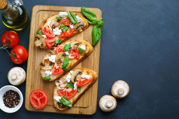 Traditional Italian bruschetta with chopped tomatoes, champignons, ricotta and basil, flat lay with free space for text. Appetizing food background