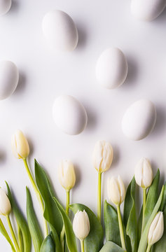 Flowers and white eggs on a white background. Flat lay.