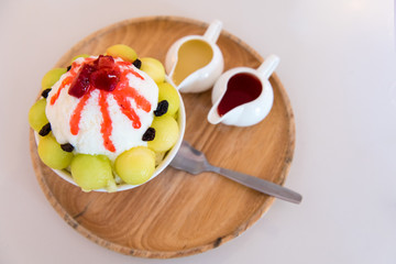 Bingsu ( Korea food) melon served with sweetened condensed milk on table