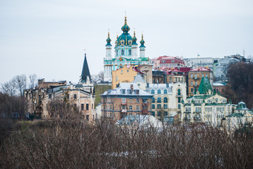 City of Kyiv (Kiev), capital of Ukraine, panorama. Colorful houses of the so-called Andriivskyi Uzviz. Cloudy spring afternoon.