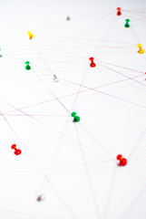 Background. Abstract concept (idea) of network, social media, internet, teamwork,  communication abstract. Colorful push pins linked together by red thread. Isolated. Entities connected.