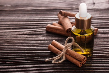 Cinnamon essential oil on a wooden background