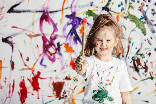 Cute child with smuges of colorful paint