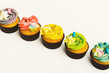 Tasty muffins with buttercream isolated on white