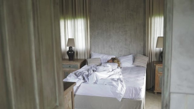 cute nice girl or woman sleeping in her house (bedroom, bed), dreaming, having nap, relaxing, resting during the day