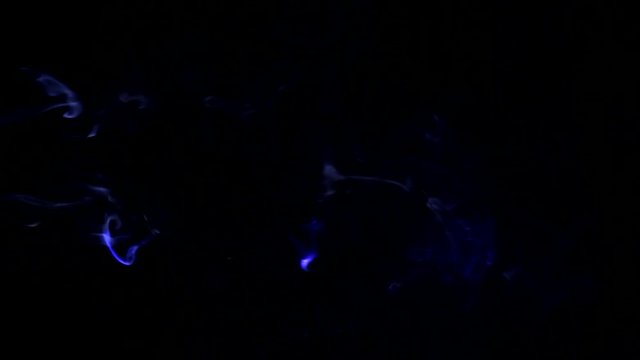 Dym podświetlony na kolorowo przelatujący od lewej do prawej. Abstrakcyjne wzory z dymu na czarnym tle.