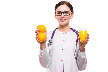 Female nutritionist hold oranges and glass of fresh juice in her hands on white background