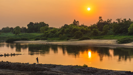 Naklejka premium Lonely people watching the sunset at the river alone.