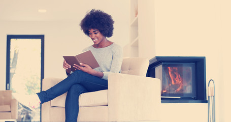 black woman at home reading book
