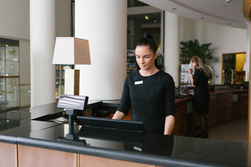 Pretty hotel worker working in reception