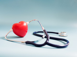 red heart using deep blue stethoscope on the blue background. Concept of love and caring patient by...