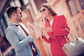 Young couple in love,eating sandwich after shopping