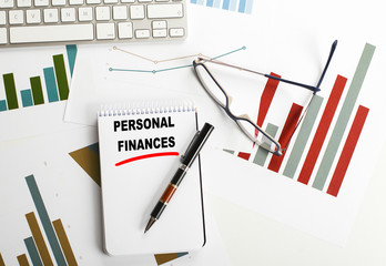 Conceptual background with the words Personal finances written in the notebook that is next to...
