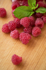 Fresh and sweet raspberries on wooden background
