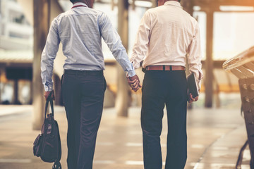 Two Asian business men are walking hand in hand and taking care of each other.The concept of sex couples is correct according to the rights of each person.