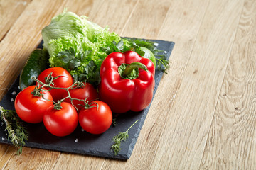 Organic closeup still life of assorted fresh vegetables and herbs on rustic wooden background, topview, selective focus.