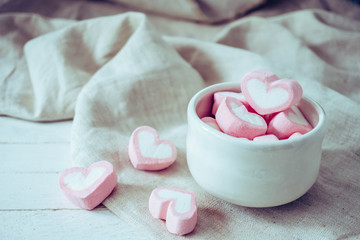 Heart shape marshmallows in white mug on wood background, sweet and  love concept