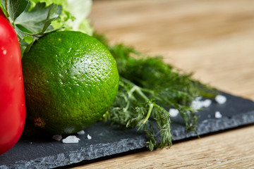 Organic closeup still life of assorted fresh vegetables and herbs on rustic wooden background, topview, selective focus.