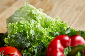 Organic closeup still life of assorted fresh vegetables and herbs on rustic wooden background, topview, selective focus.