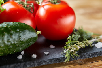 Organic closeup still life of assorted fresh vegetables and herbs on rustic wooden background, topview, selective focus.