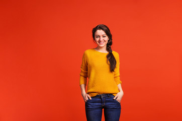 Portrait of a young beautiful woman in studio on a red background.