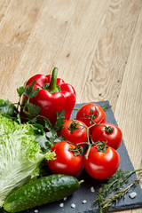 Organic closeup still life of assorted fresh vegetables and herbs on rustic wooden background, topview, selective focus.