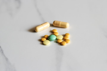 Assorted pharmaceutical medicine pills, tablets and capsules over marble background
