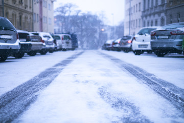 Prague city street under the snow. Cars driving on a blizzard road. Snow calamity in the city.  Snow covered cars. Winter
