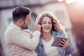 Fototapeta premium Trendy young couple listening music on a digital tablet