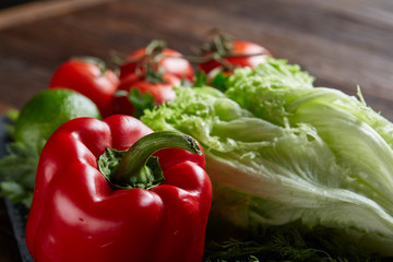 Close-up still life of assorted fresh vegetables and herbs on vintage wooden background, top view, selective focus.