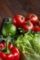Close-up still life of assorted fresh vegetables and herbs on vintage wooden background, top view, selective focus.