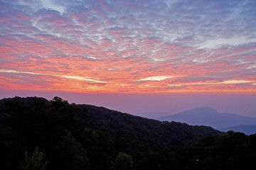 Sun rise purple orange sky background with landscape of mountain and tree with cloudy sky