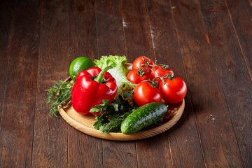 Close-up still life of assorted fresh vegetables and herbs on vintage wooden background, top view, selective focus.