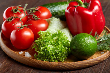 Close-up still life of assorted fresh vegetables and herbs on vintage wooden background, top view, selective focus.