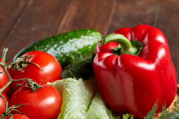 Close-up still life of assorted fresh vegetables and herbs on vintage wooden background, top view, selective focus.